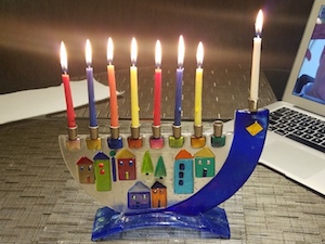 A channukia with with lit candles for the seventh night